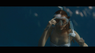 a woman in a bathing suit holding a toothbrush