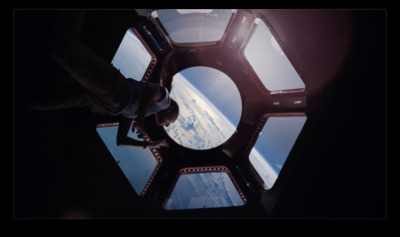 a man standing inside of a space station window