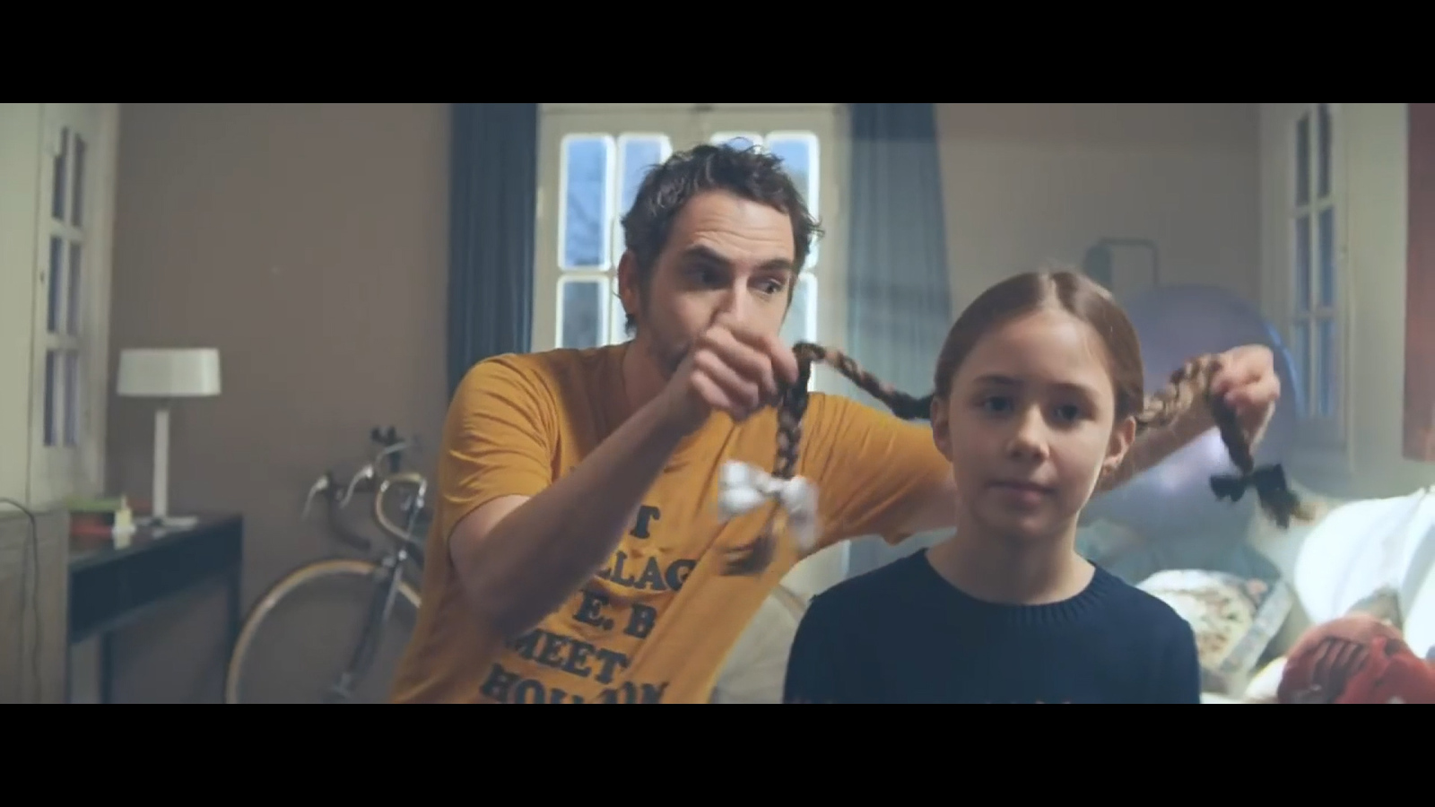 a man is blow drying a young girl's hair