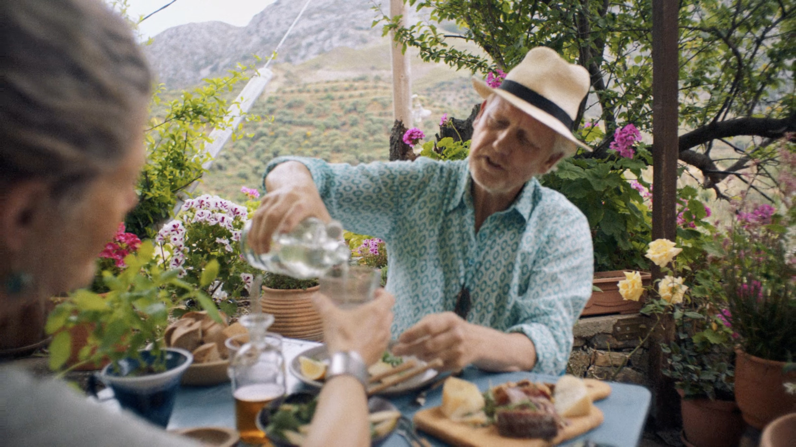 a man pouring a glass of water at a table