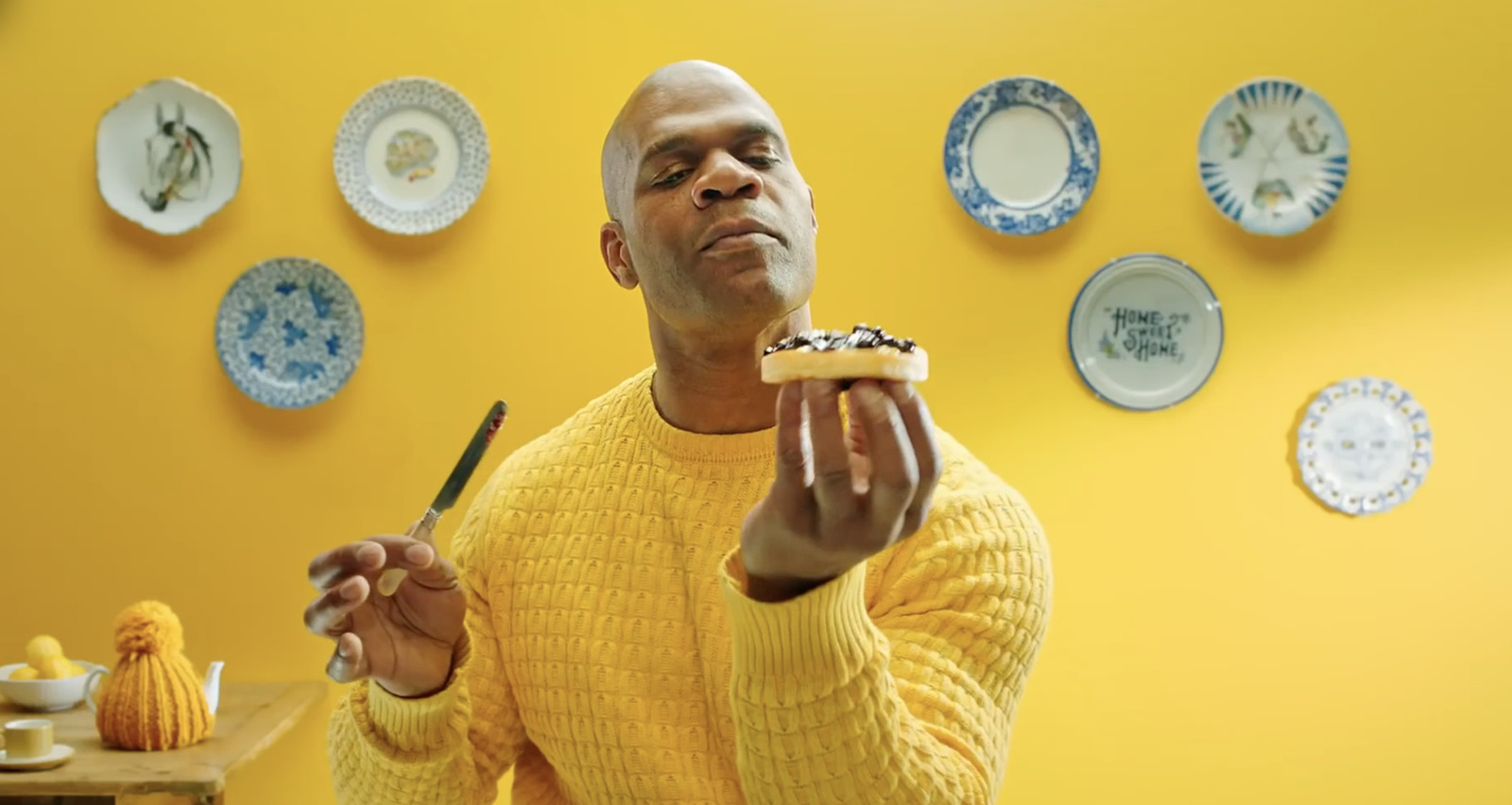 a man in a yellow sweater eating a piece of cake