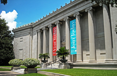 a large building with columns and flags on it