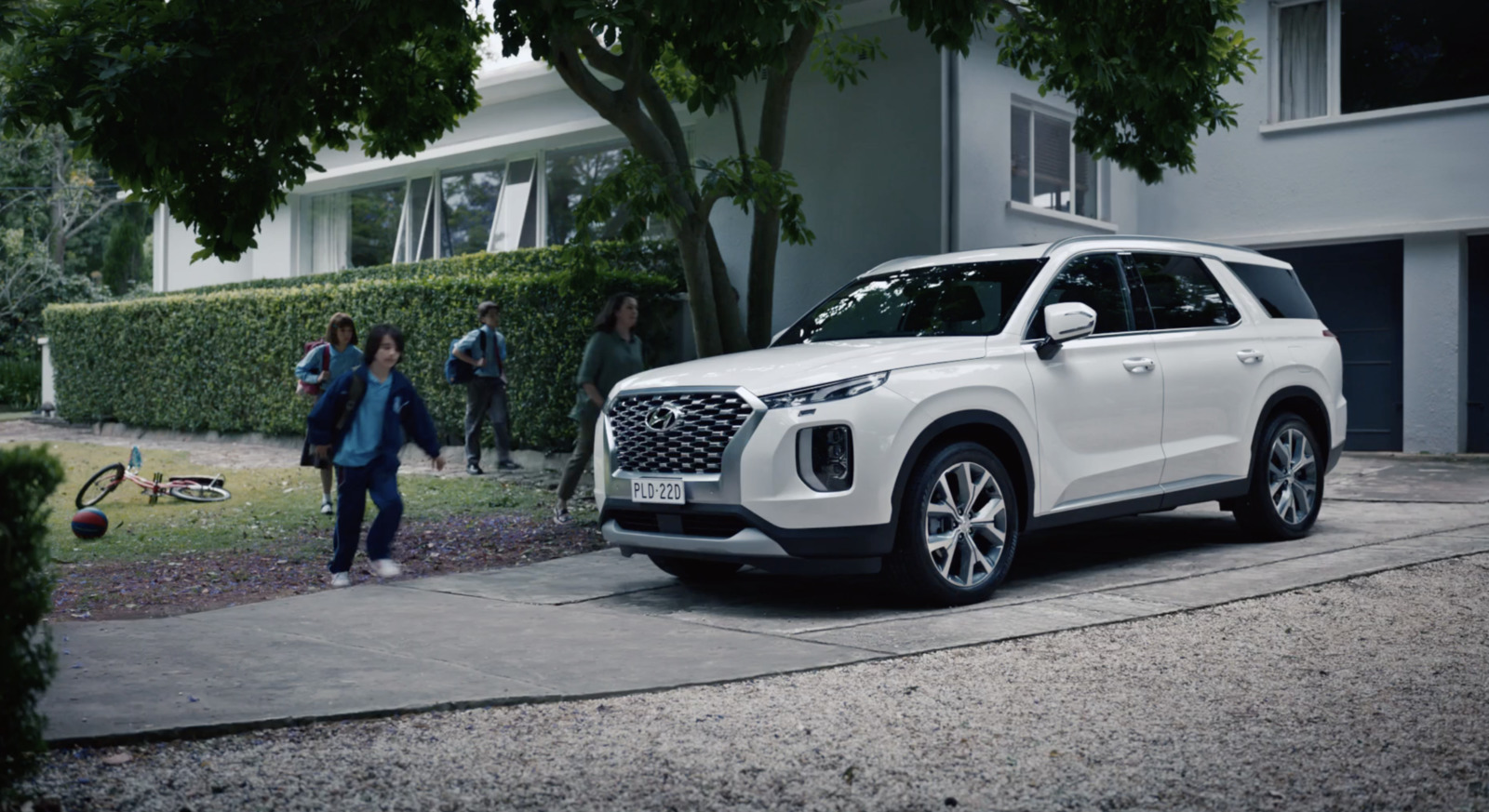 a white suv parked in front of a house