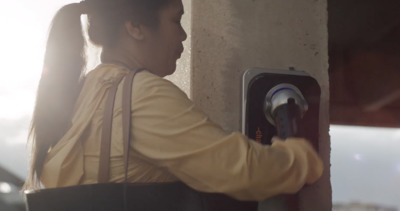 a woman is holding onto a button on a wall