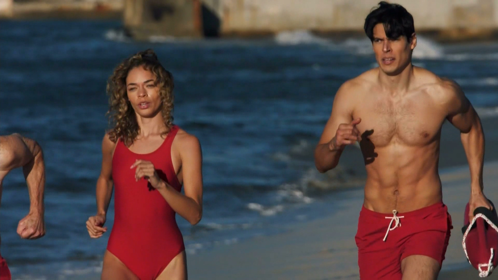 a man and a woman running on the beach