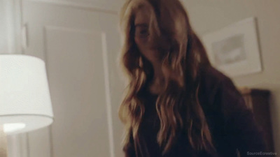 a woman with long hair standing in a room