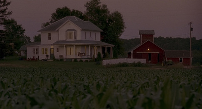 a large white house sitting on top of a lush green field