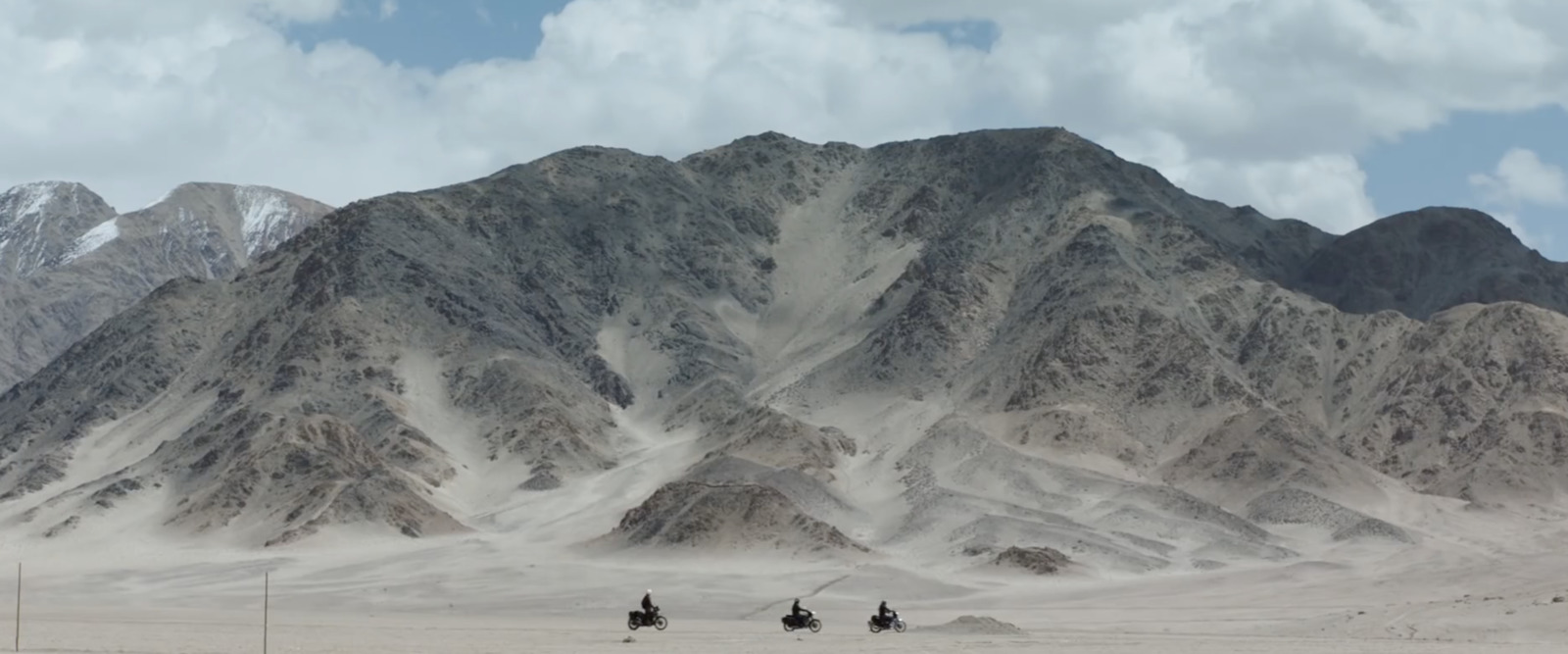 a group of people riding horses through a desert