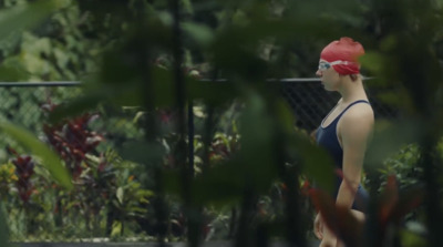 a woman in a bathing suit and a red hat