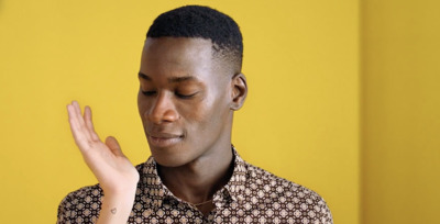 a man is holding his hand up in front of his face