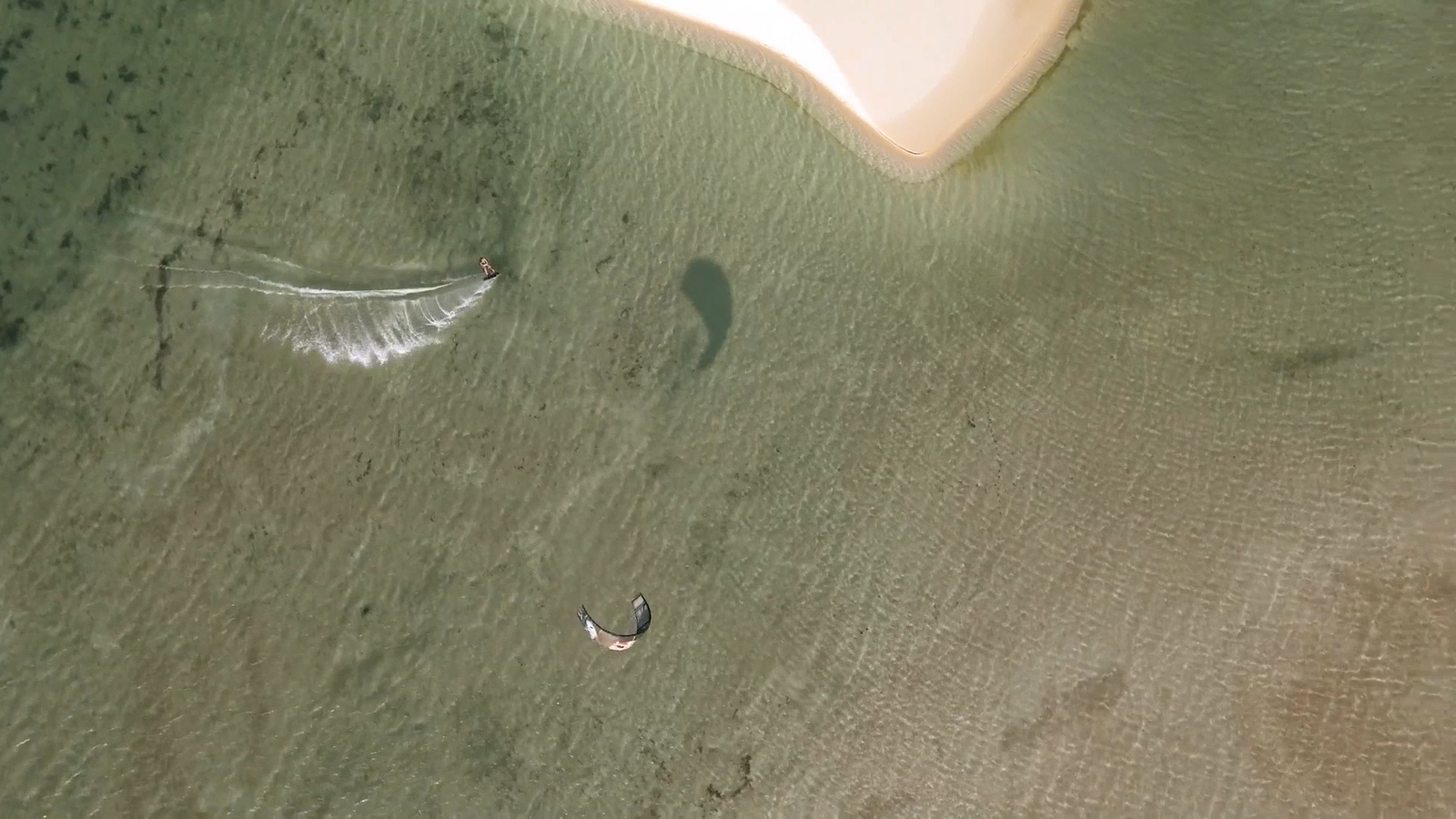 an aerial view of a beach with two people in the water