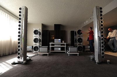 a man and a woman standing in a room with speakers