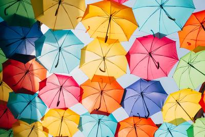 a group of multicolored umbrellas hanging from a ceiling