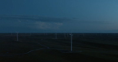 a group of wind turbines in a field at night