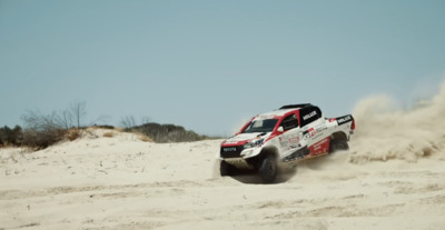 a red and white truck driving through the sand