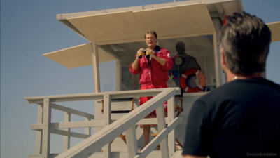 a man standing on top of a life guard tower