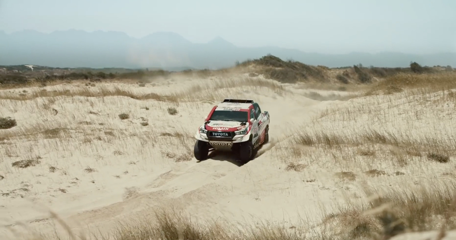 a truck is driving through the sand dunes