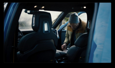 a man sitting in the driver's seat of a blue truck