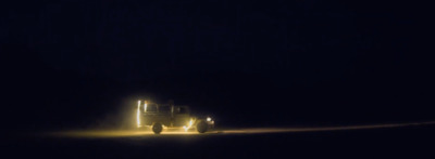 a truck driving down a dark road at night