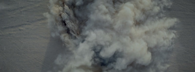 a jet flying through the air covered in smoke