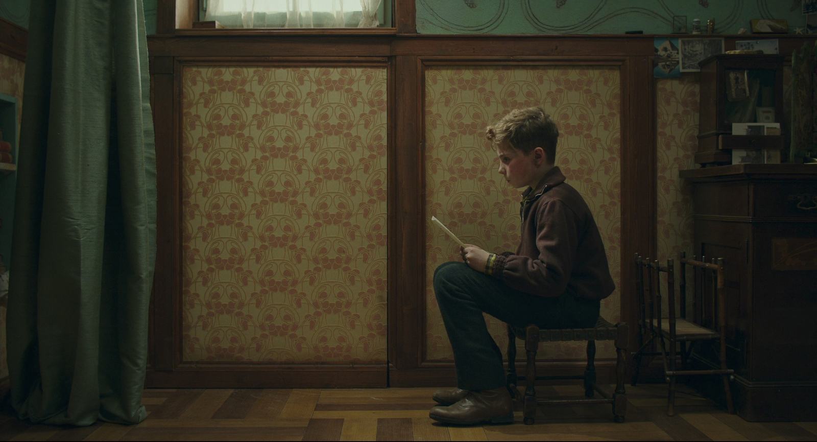 a man sitting on a chair in front of a window