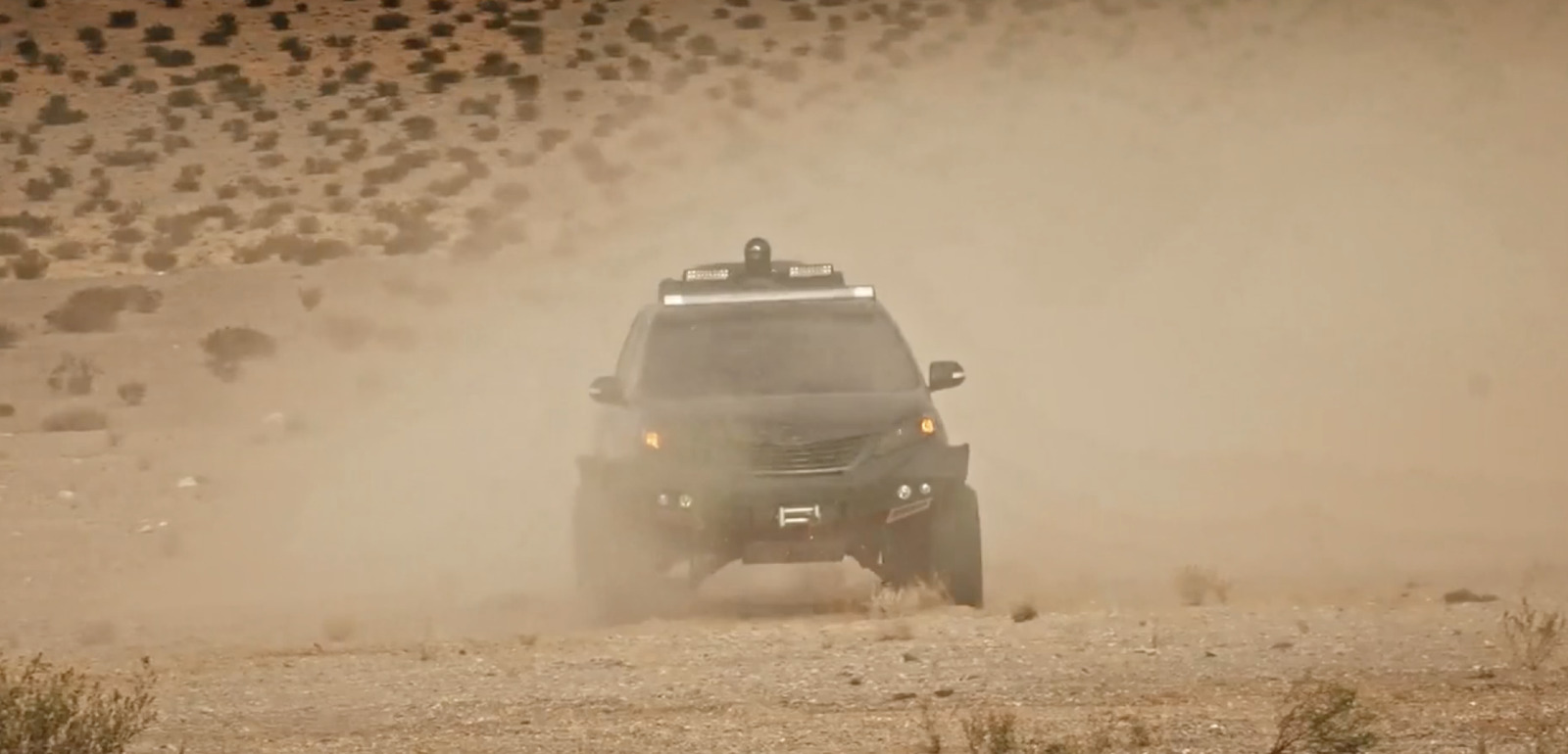 a jeep driving through the desert on a dirt road