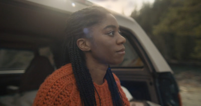 a woman with braids sitting in the back of a car