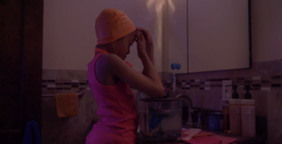 a woman in a pink dress is washing her hands