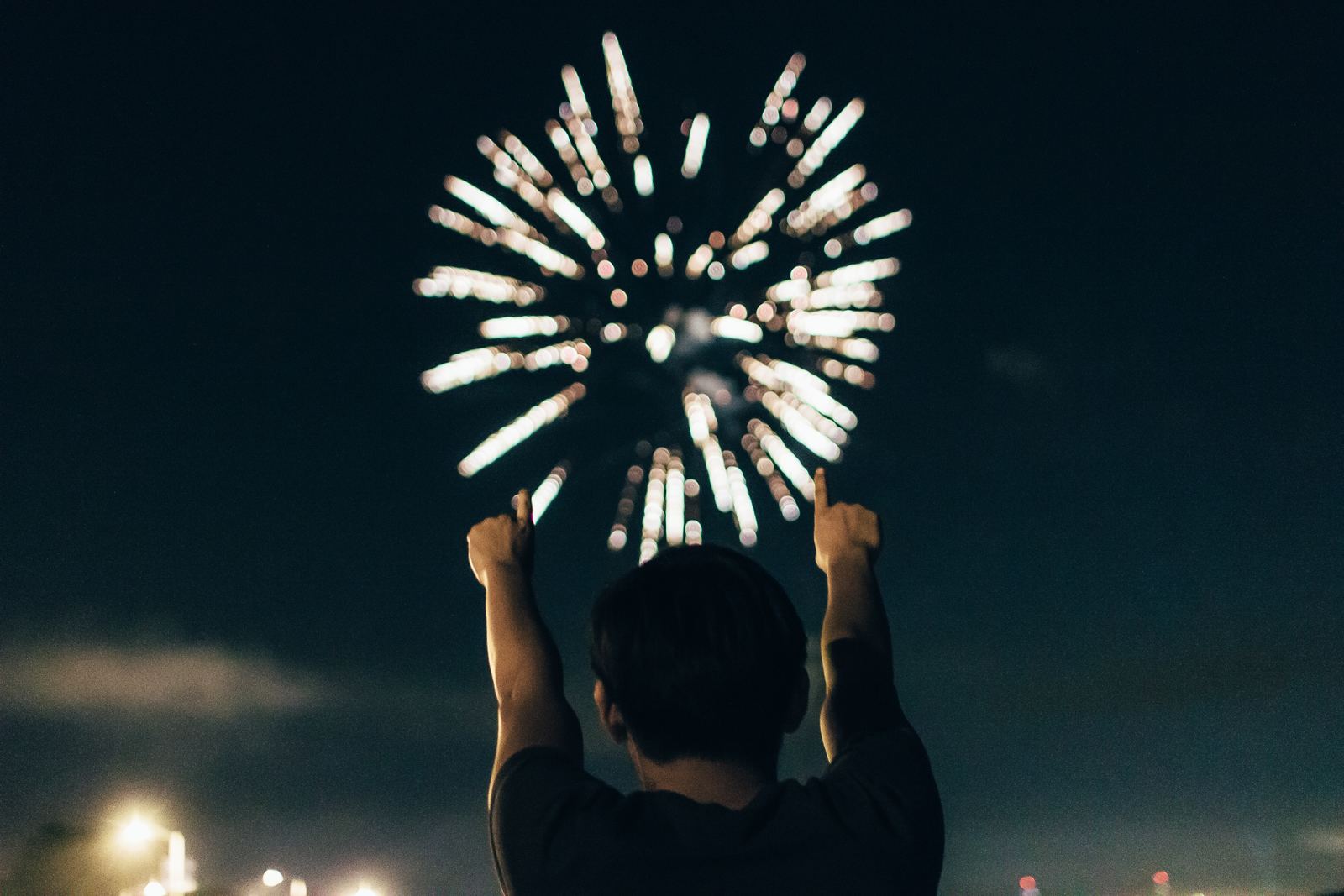 a person standing in front of a fireworks display