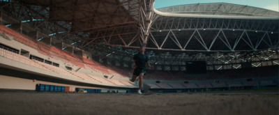 a man standing in a stadium holding a skateboard