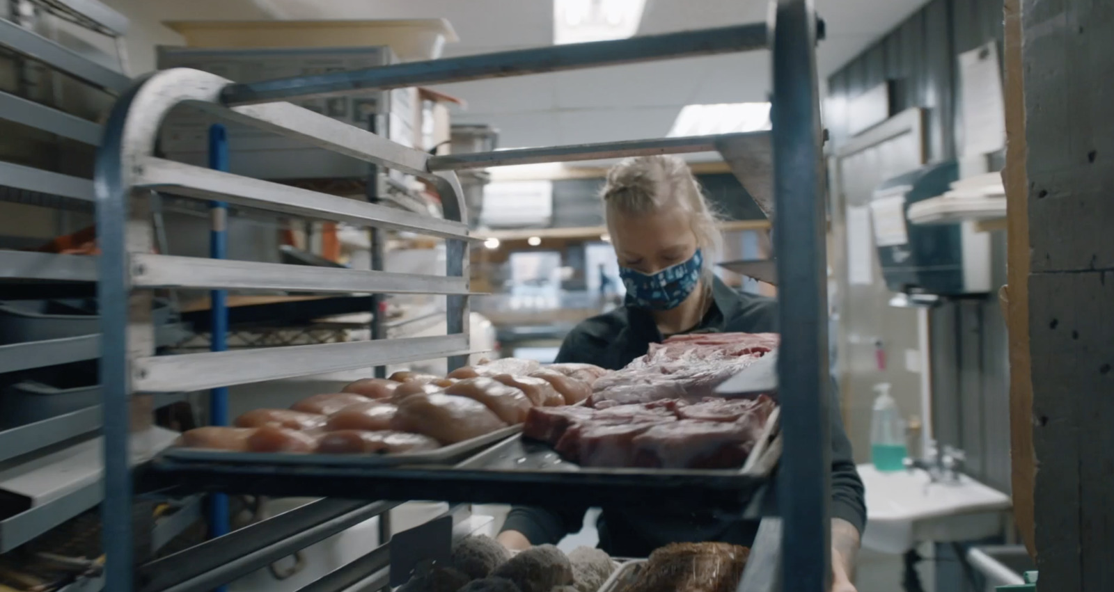 a woman wearing a face mask in a bakery