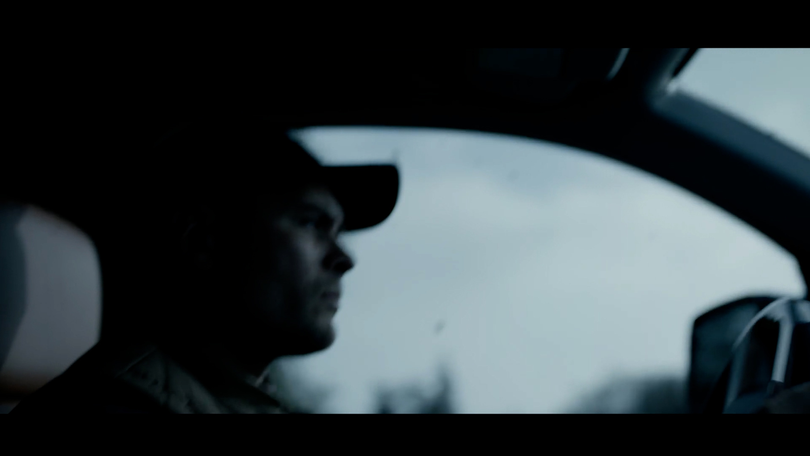 a man sitting in a car looking out the window