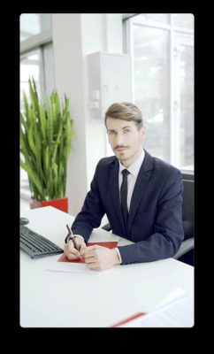 a man sitting at a desk writing on a piece of paper