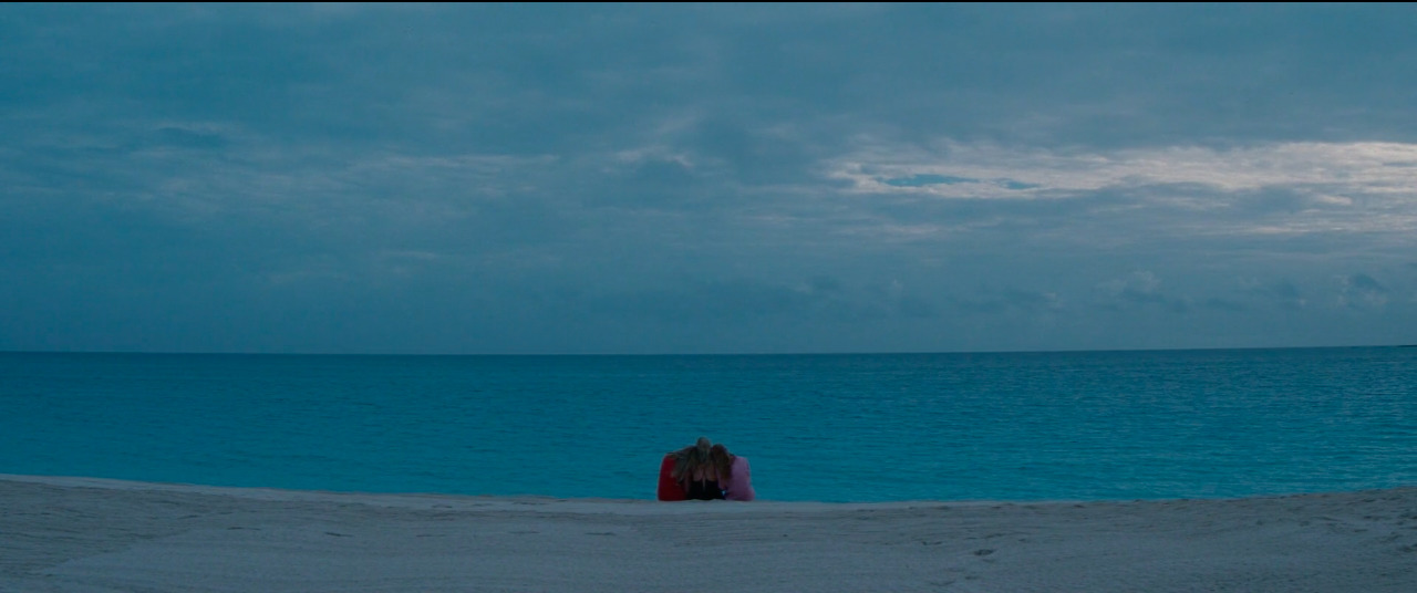 a person sitting on a beach next to the ocean