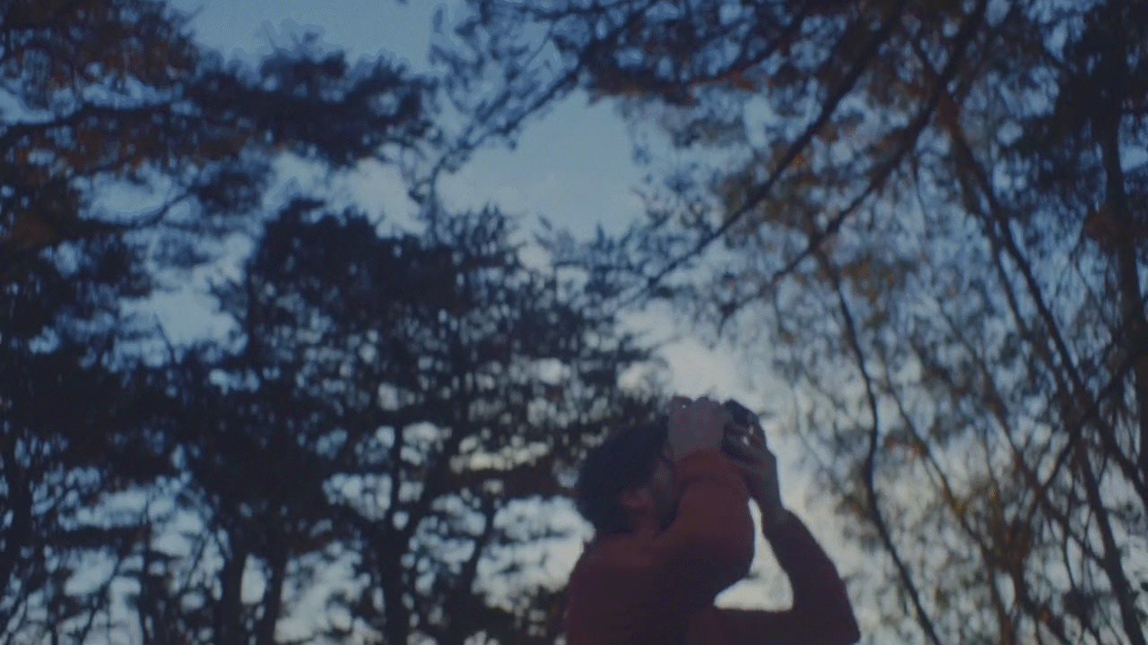 a man taking a picture of trees with his cell phone