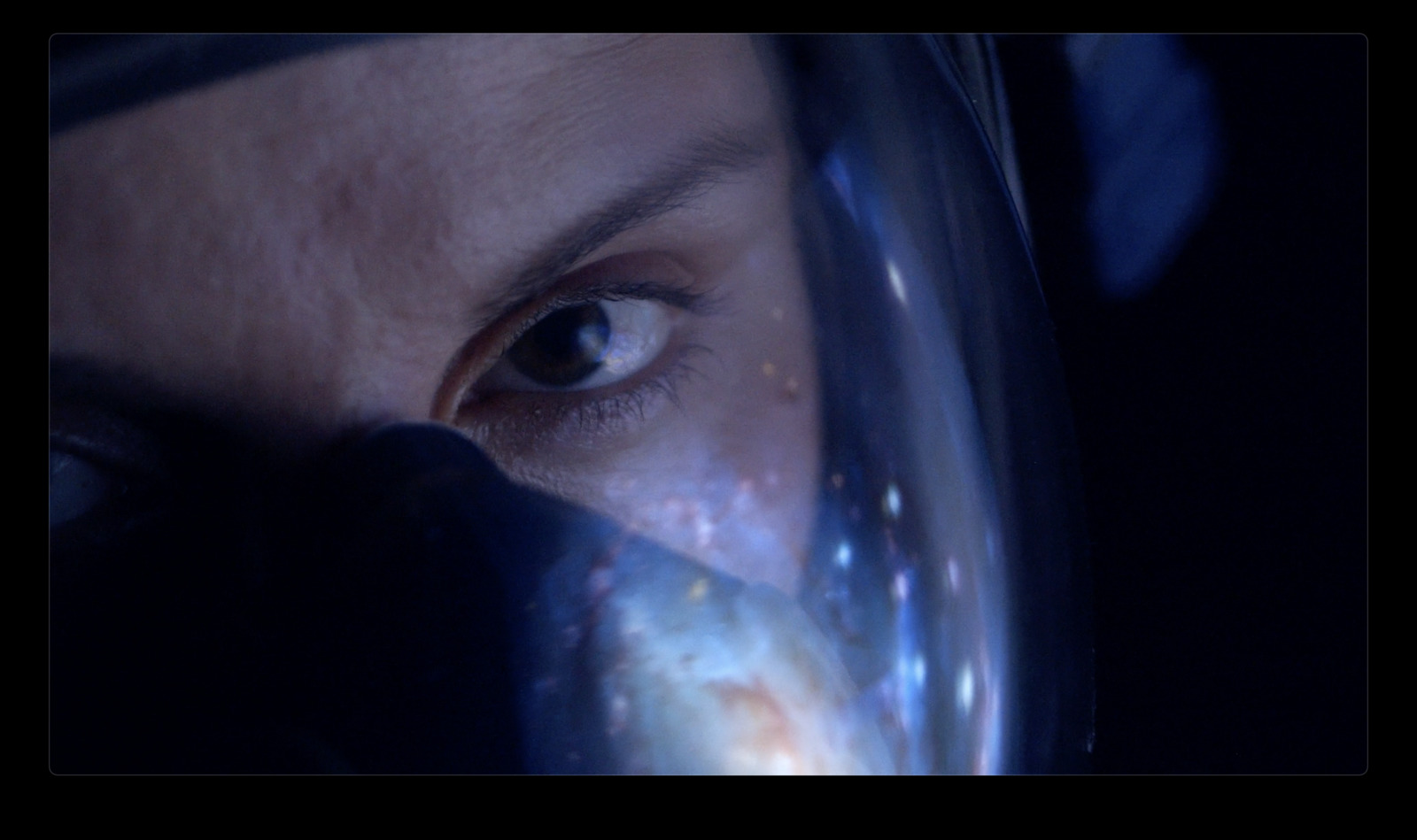 a close up of a person's face with a glass in front of her