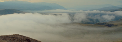 a view of a mountain range covered in clouds