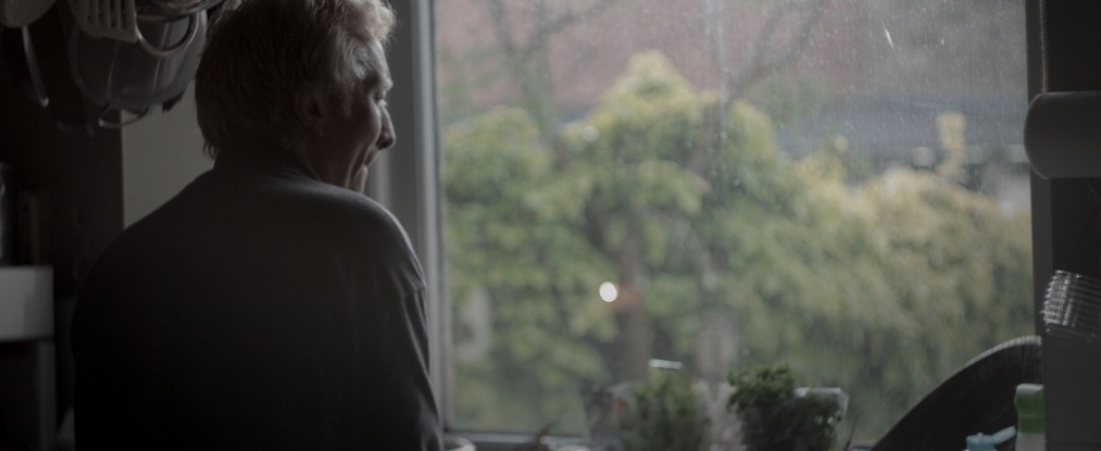 a man standing in front of a window in a kitchen