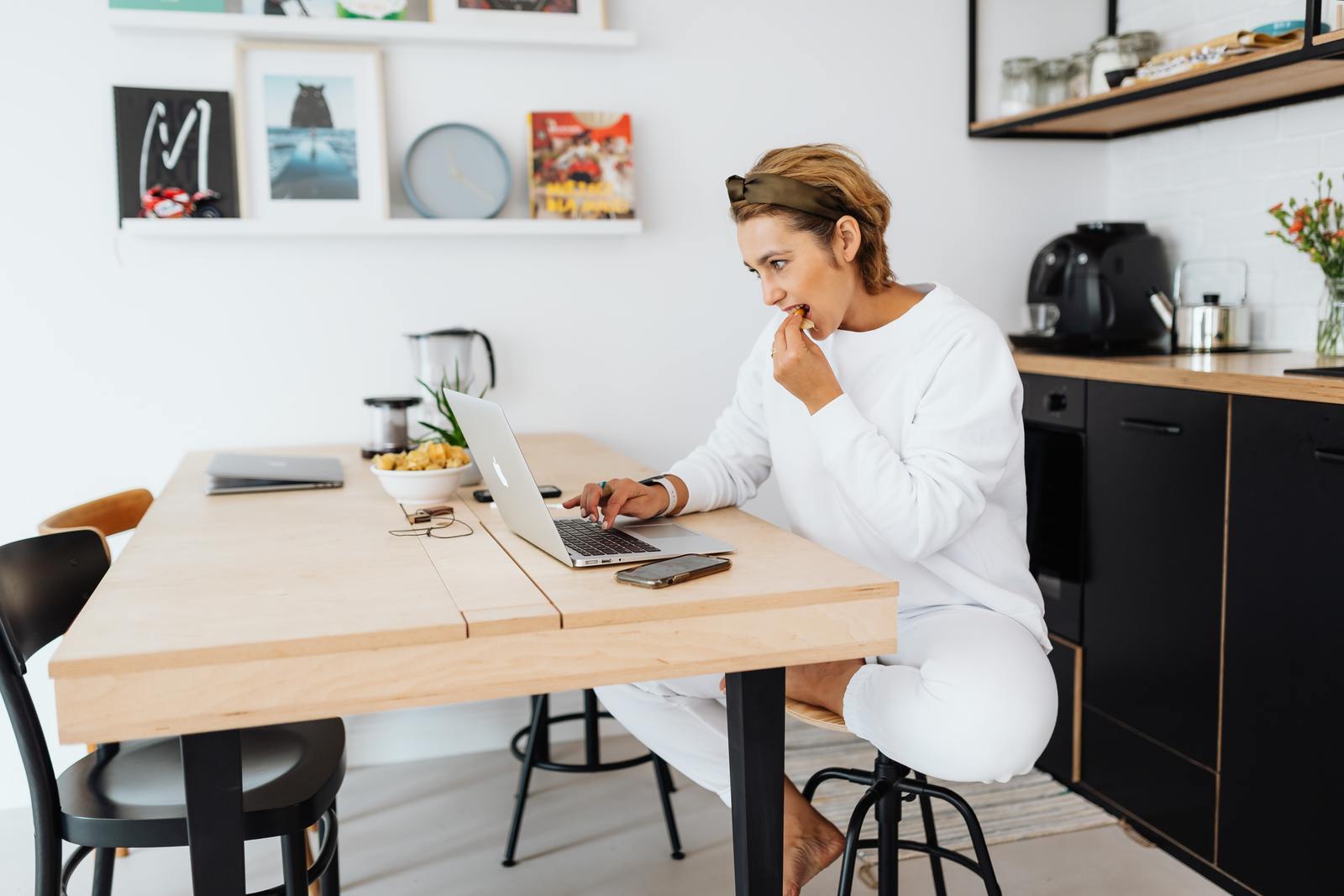 a woman sitting at a table using a laptop computer