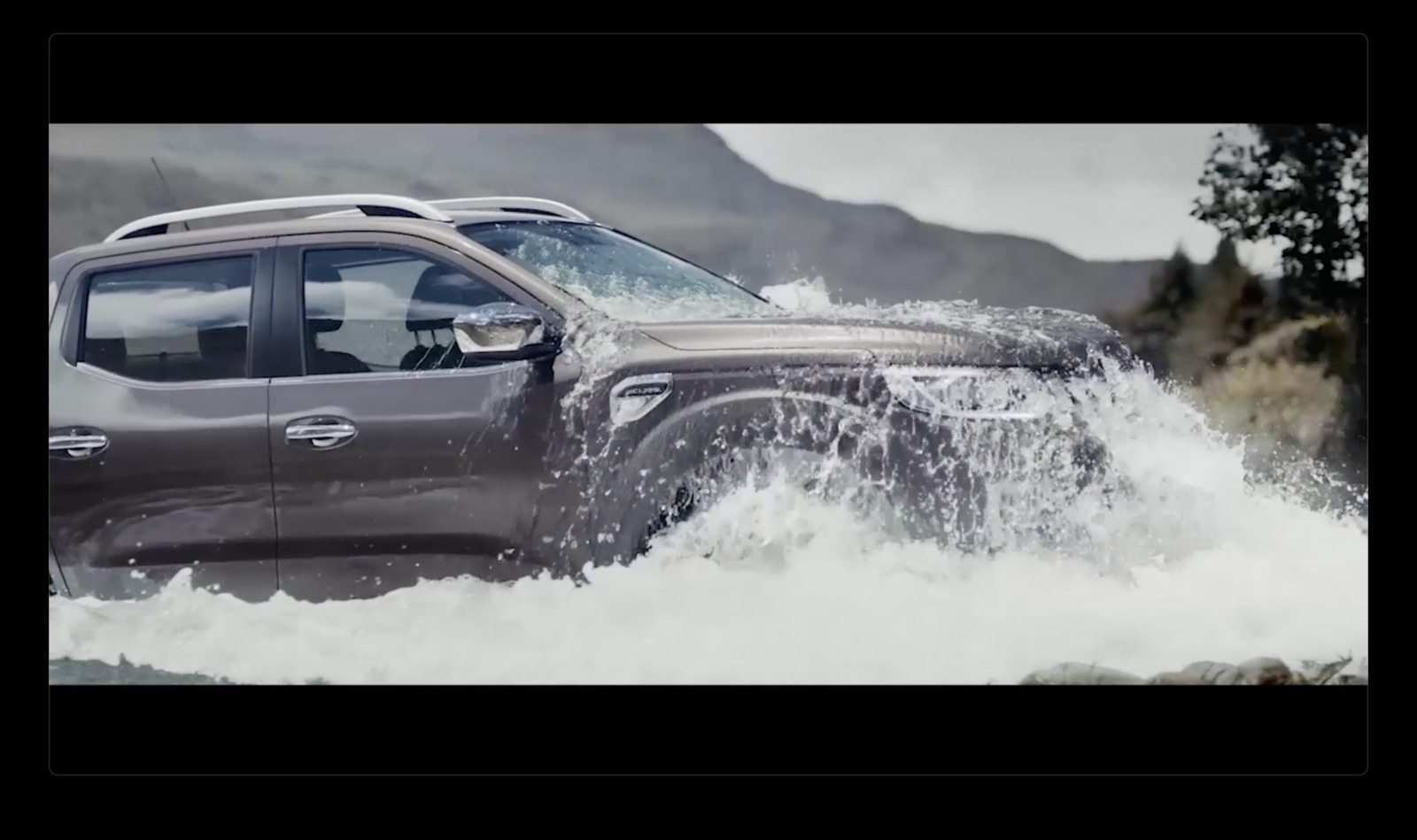 a grey truck driving through a body of water