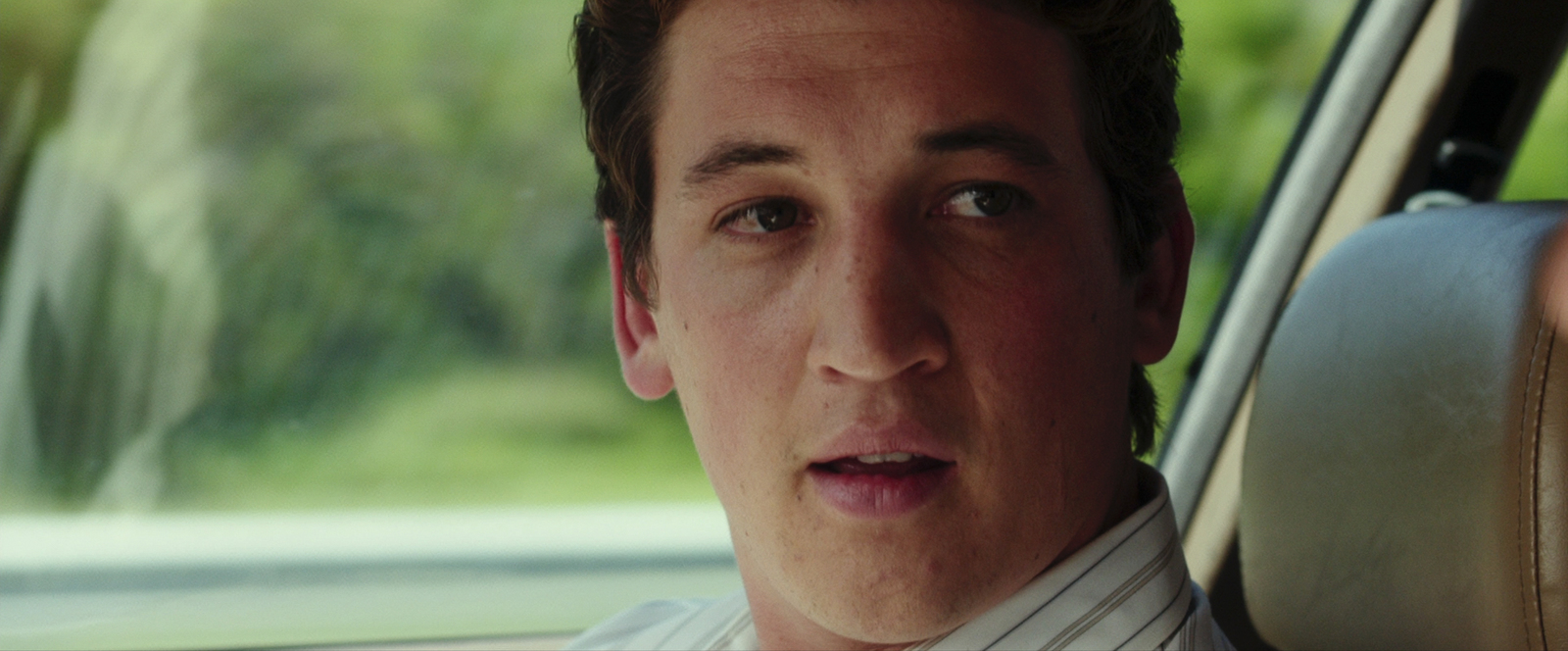 a man sitting in a car with a surprised look on his face