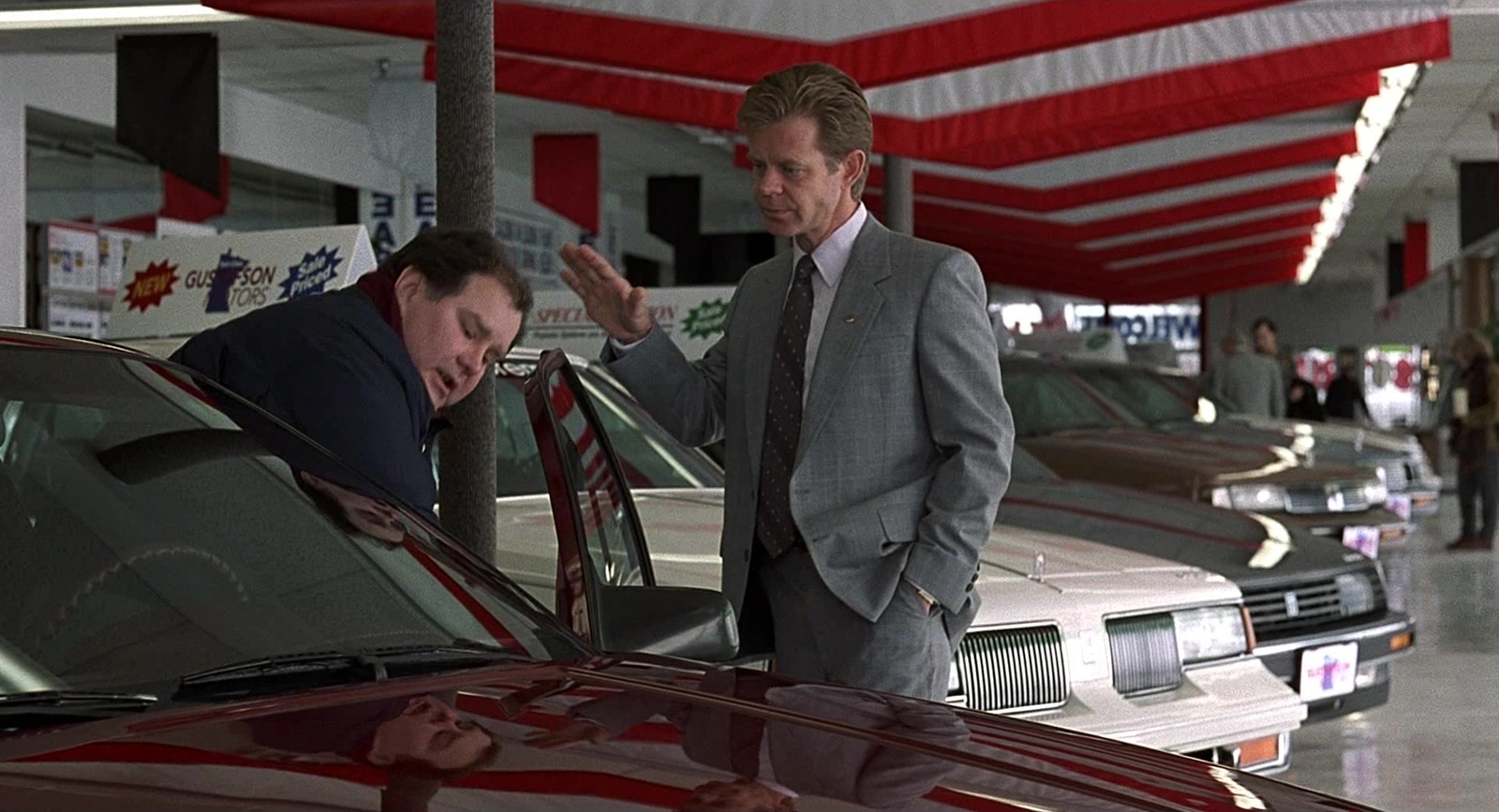 a couple of men standing next to each other near a car