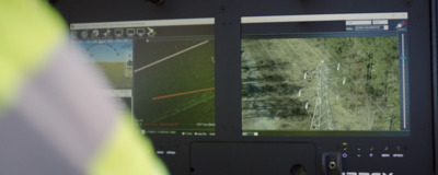 a man in a yellow vest looking at a computer screen