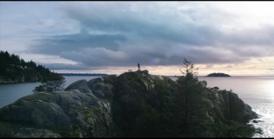 a person standing on top of a large rock near the ocean