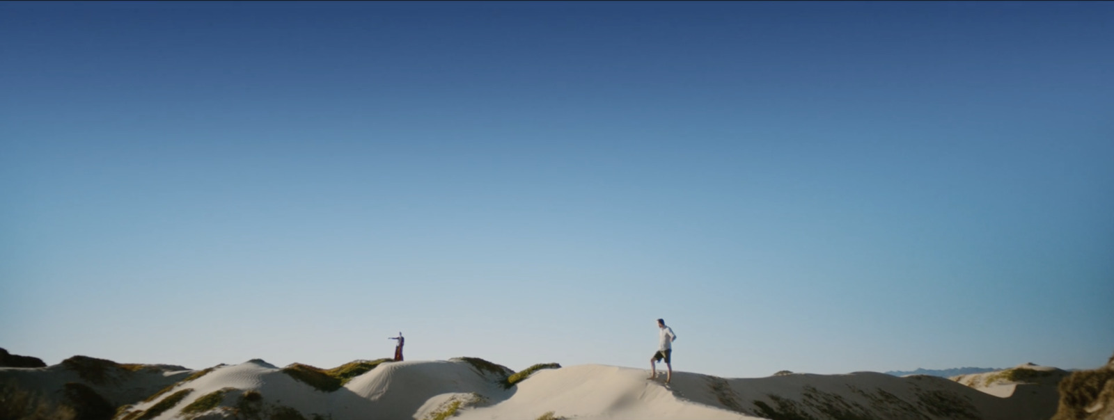 two people standing on top of a snow covered hill