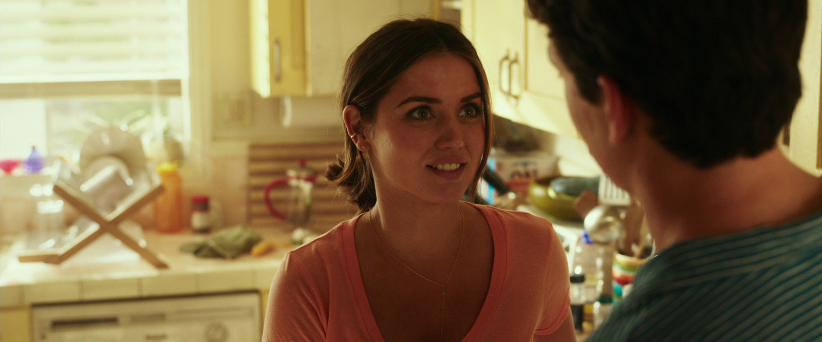 a woman talking to a man in a kitchen