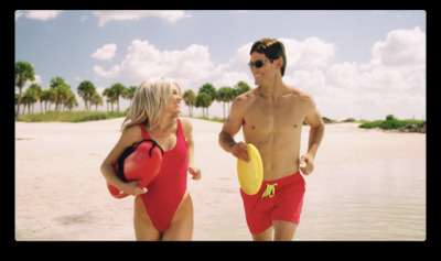 a man and a woman in bathing suits on a beach