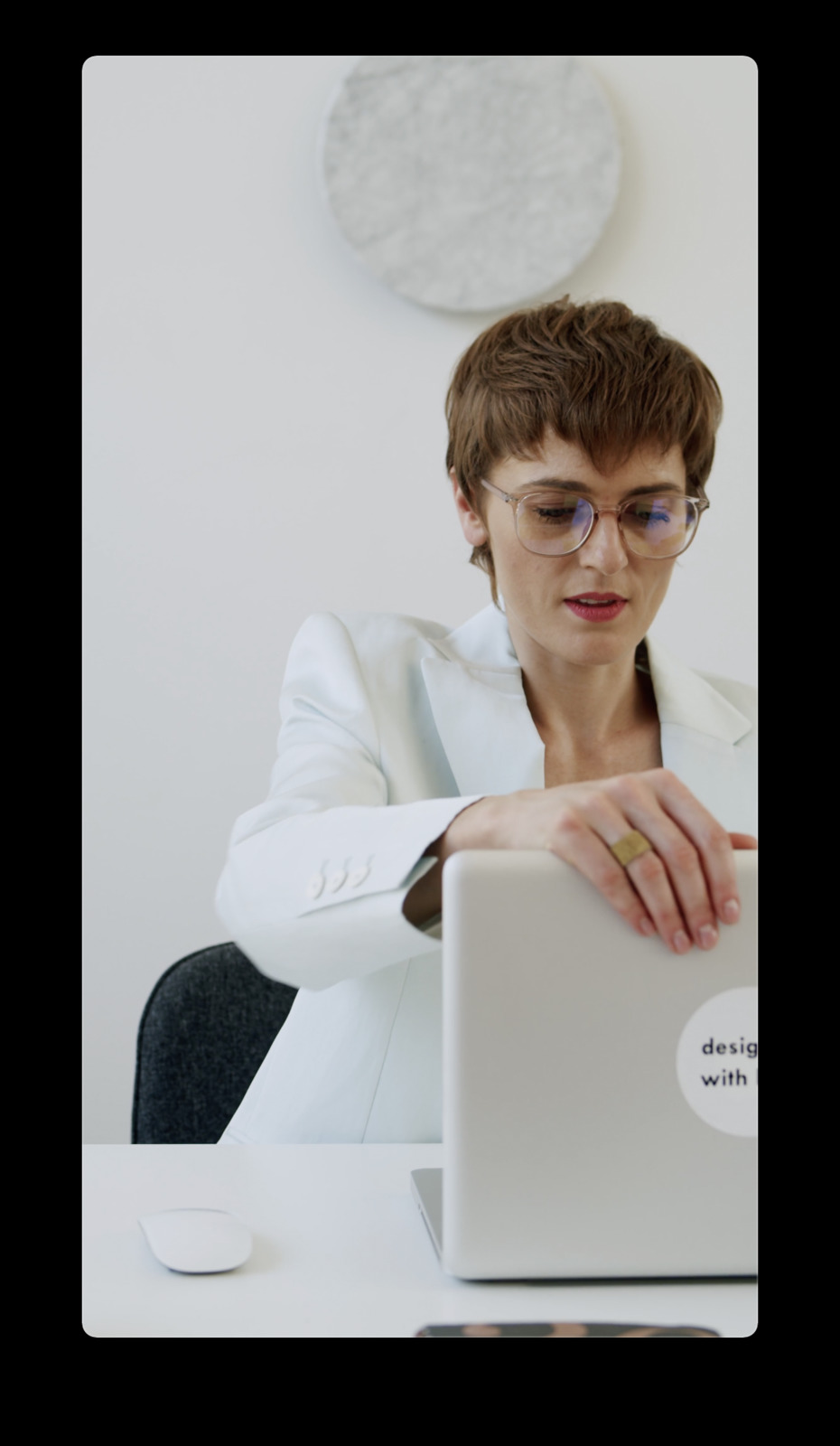 a woman sitting at a desk using a laptop computer