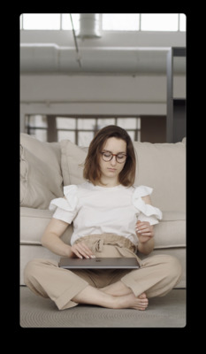 a woman sitting on a couch using a laptop computer