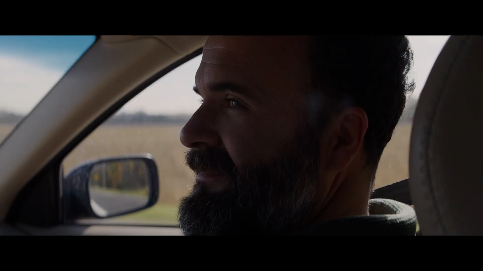 a man with a beard sitting in a car